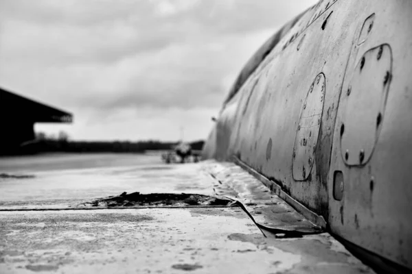 Grayscale Záběr Rezavého Opuštěného Letadla Pod Zataženou Oblohou Rozmazaným Pozadím — Stock fotografie