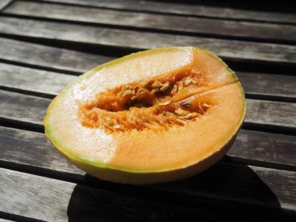 Sebuah Tembakan Closeup Dari Setengah Melon Kuning Atas Meja Kayu — Stok Foto