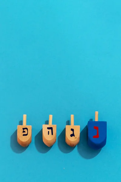 Vertikální Snímek Chanuka Dreidel Modrém Pozadí Hra Hraná Během Židovských — Stock fotografie