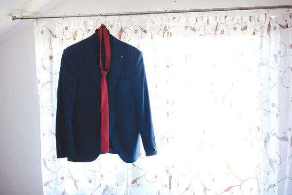 Niebieska Kurtka Garnituru Czerwonym Krawatem Wiszącym Pręcie Kurtyny — Zdjęcie stockowe