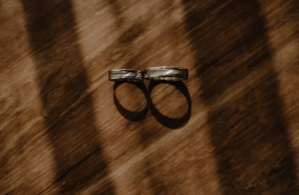 Vysokoúhlý Záběr Snubních Prstenů Dřevěném Povrchu Stínem — Stock fotografie