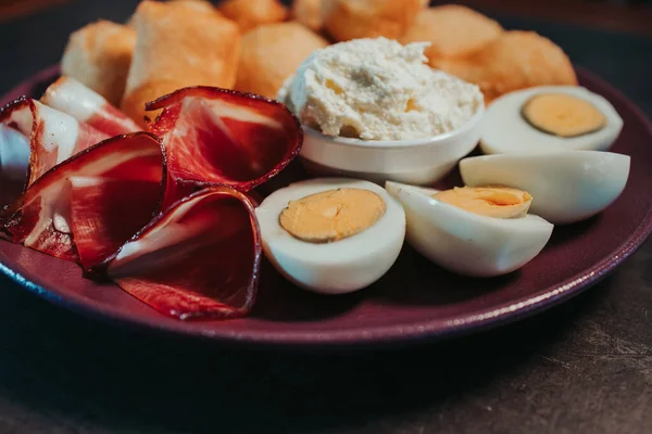 烤鸡蛋和咸肉的特写镜头和放在桌上盘子里的副菜 — 图库照片