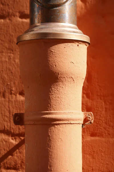 Eine Vertikale Aufnahme Einer Orangefarbenen Wasserleitung Einem Sonnigen Tag — Stockfoto