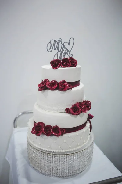Egy Függőleges Felvétel Egy Négyemeletes Esküvői Tortáról Rózsákkal Díszítve Tálcán — Stock Fotó