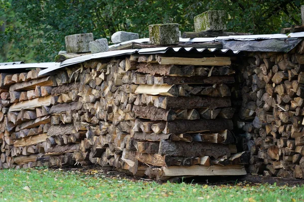 Eine Nahaufnahme Von Aufeinandergestapelten Holzbohlen Unter Einem Metalldach Feld — Stockfoto