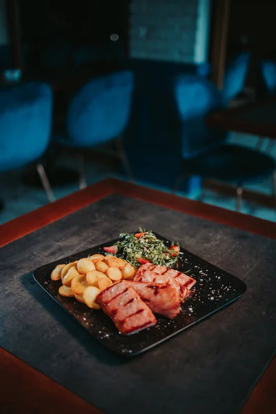 テーブルの上のプレート上にチップとサラダと揚げ魚の垂直ショット — ストック写真