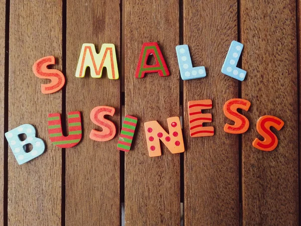 在木板上的 小企业 多彩的字母的特写镜头 — 图库照片