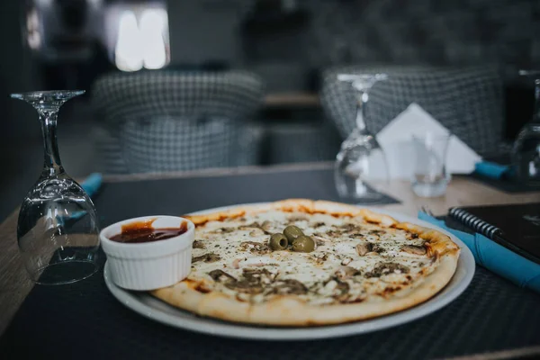 テーブルの上のプレート上にオリーブとケチャップと全体の白いビアンカピザの閉鎖 — ストック写真