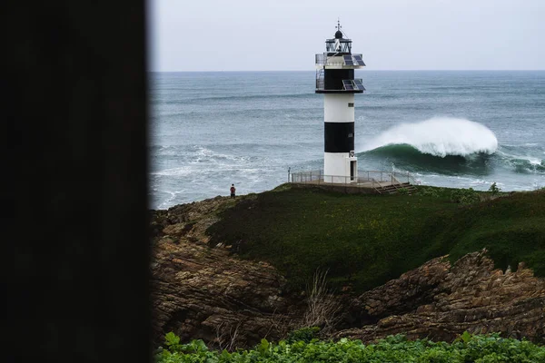 Arka Planda Dalgalanan Dalgalarla Deniz Kenarında Uzun Bir Deniz Feneri — Stok fotoğraf