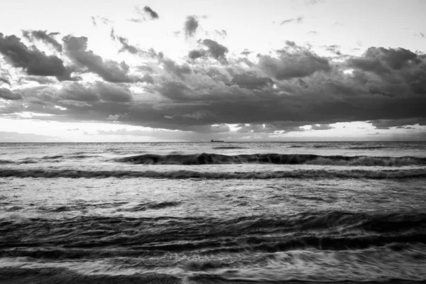 一个奇异的灰度拍摄的暴风雨波浪形海水与一个戏剧性的天空在之上 — 图库照片