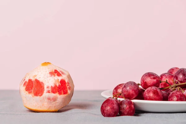 Primer Plano Racimo Uvas Pomelo Pelado Sobre Fondo Rosa Bodegón —  Fotos de Stock