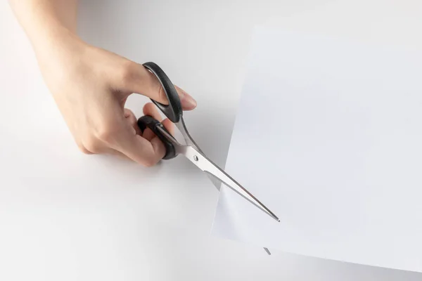 A closeup shot of a female cutting paper