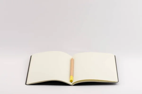 白い背景に鉛筆で区切られた開いた空白の本のクローズアップショット — ストック写真