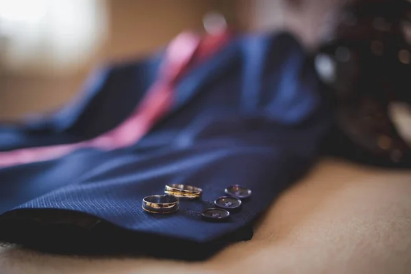 新郎の青いスーツの袖に置かれた結婚指輪の選択的なフォーカスショット — ストック写真