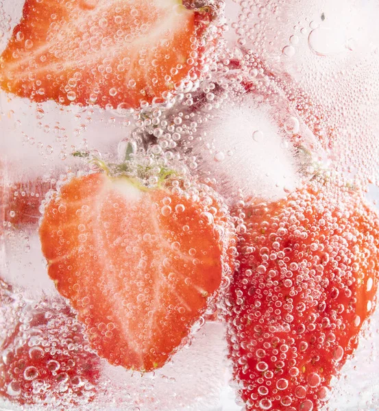 冷たい飲み物のガラスの中でイチゴのスライスのクローズアップショット — ストック写真