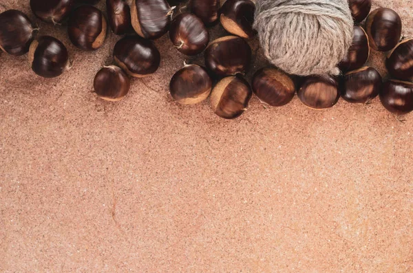 コピースペースのある茶色の表面に糸のある新鮮な栗のトップビュー — ストック写真