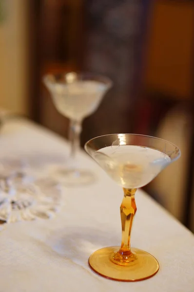 テーブルクロス付きテーブルの上にアルコール飲料付きカクテルグラスの垂直ショット — ストック写真