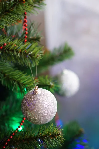 クリスマスツリーに吊るされた明るく輝くボールの垂直ショット — ストック写真
