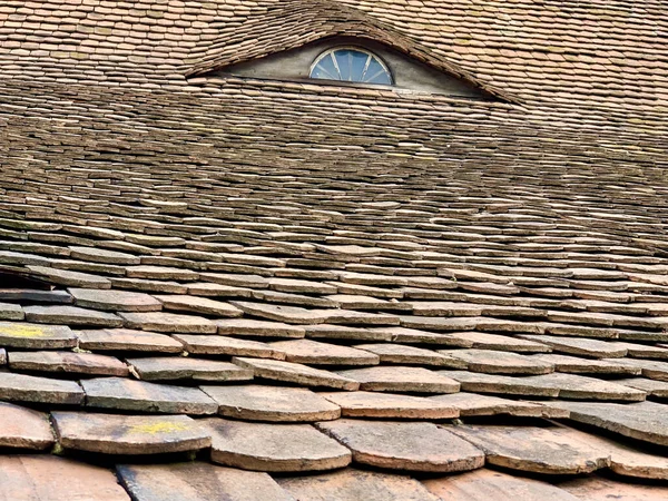 石で作られた家の屋根の上の小さな窓の閉まり — ストック写真