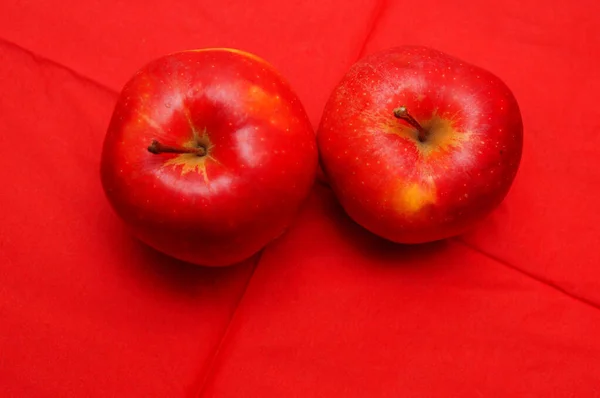 Kırmızı Arkaplanda Iki Kırmızı Elmanın Yakın Plan Çekimi — Stok fotoğraf