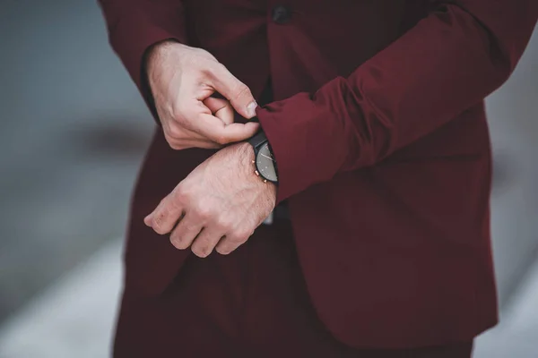 Een Man Met Een Rood Pak Die Zijn Horloge Draagt — Stockfoto