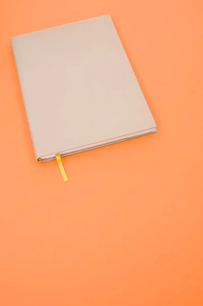 Крупный План Серого Блокнота Желтой Закладкой Оранжевом Фоне — стоковое фото