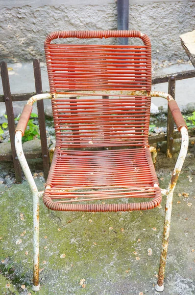 Asfalttaki Kırmızı Paslı Bahçe Sandalyesinin Dikey Görüntüsü — Stok fotoğraf
