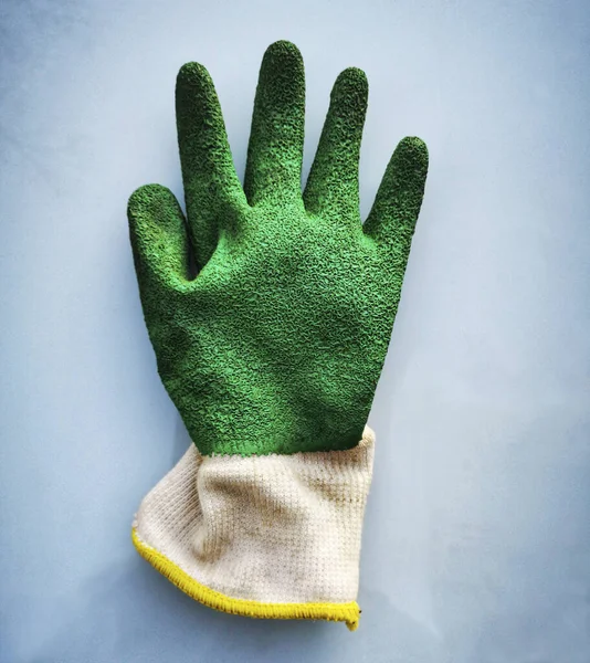 浅蓝色底色绿色旧橡胶手套的垂直特写 — 图库照片