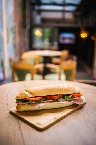 テーブルの上に肉 チーズ 野菜とおいしい潜水艦サンドイッチのクローズアップ — ストック写真
