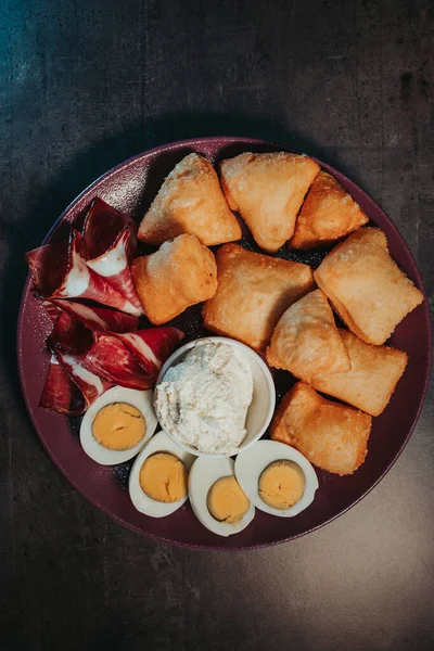 一个垂直拍摄的油炸面团棒 与卷火腿和煮熟的鸡蛋一起食用 — 图库照片