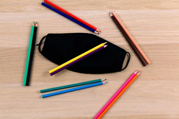 Top View Closeup Black Mask Various Colored Pencils Wooden Table — Stock Photo, Image