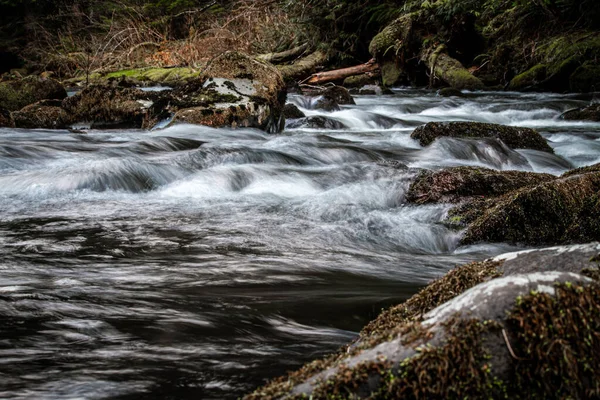 Eine Lange Texturaufnahme Eines Wasserfalls Umgeben Von Bemoosten Felsen — Stockfoto