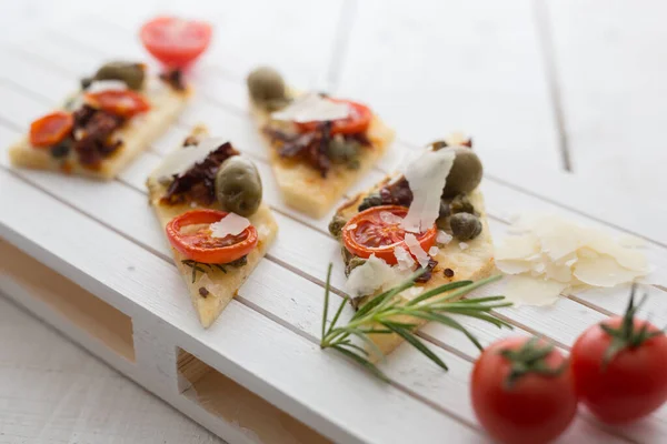 Shot Tasty Bruschettas Tomatoes Olives Capers Cheese Served Wooden Board — Stock Photo, Image