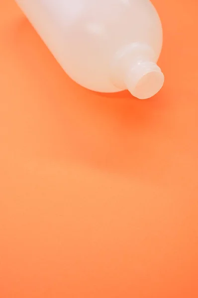 Вертикальный Снимок Пластиковой Бутылки Оранжевом Фоне — стоковое фото