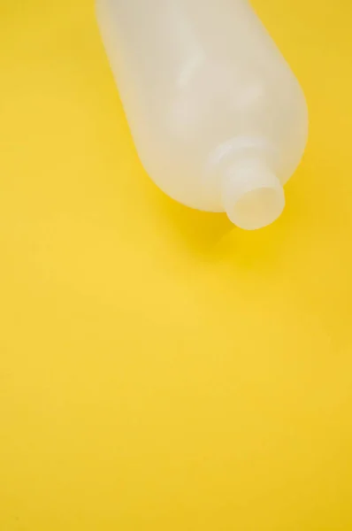 Tiro Vertical Uma Garrafa Plástico Fundo Amarelo — Fotografia de Stock