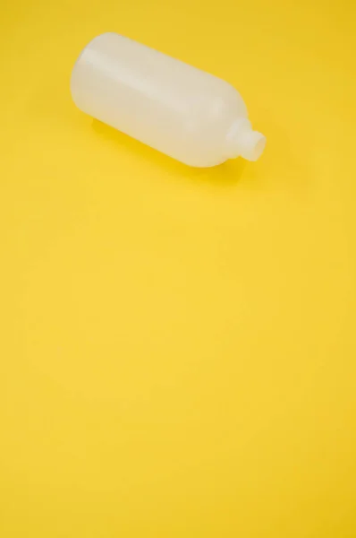 Colpo Verticale Una Bottiglia Plastica Uno Sfondo Giallo — Foto Stock