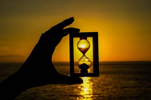 Primer Plano Una Mano Sosteniendo Reloj Arena Una Hermosa Puesta — Foto de Stock