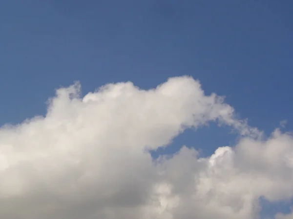 Ein Blauer Tageshimmel Mit Flauschigen Baumwollartigen Wolken Als Hintergrund — Stockfoto