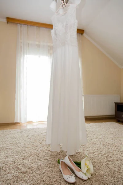 Egy Gyönyörű Fehér Esküvői Ruha Lóg Csilláron Lapos Cipők Virágok — Stock Fotó