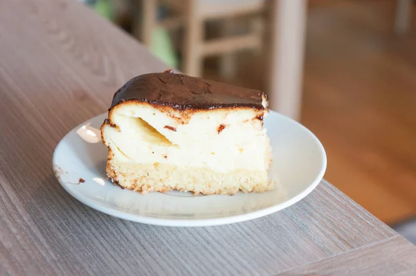 ホワイトプレートにチョコレートカバー付きのフレッシュチーズケーキの選択的フォーカスショット — ストック写真