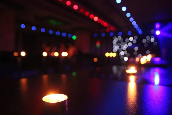 Enfoque Selectivo Una Vela Una Mesa Con Luces Borrosas Fondo —  Fotos de Stock