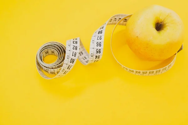 Ett Äpple Med Måttband Isolerad Gul Bakgrund — Stockfoto