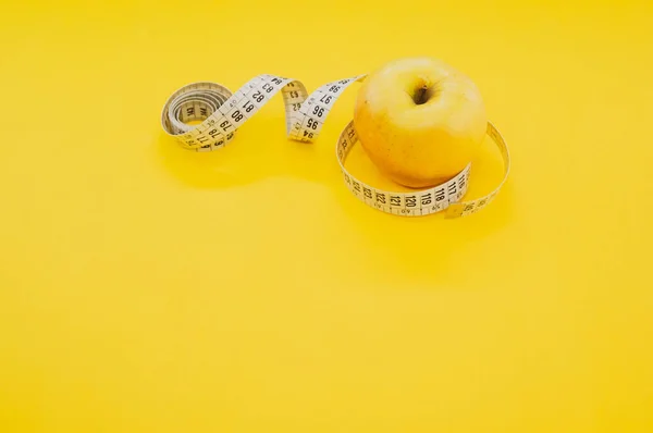Ein Apfel Mit Maßband Isoliert Auf Gelbem Hintergrund — Stockfoto