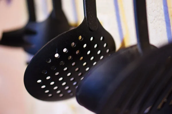 Closeup Black Plastic Spatula Holes Hanging Kitchen Blurry Background — Stock Photo, Image