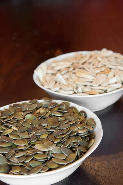 Closeup Two White Bowls One Cleaned Pumpkin Seeds Other Shells — Stock Photo, Image
