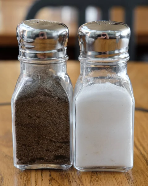 Eine Nahaufnahme Von Glassalz Und Pfefferstreuern Auf Einem Hölzernen Hintergrund — Stockfoto