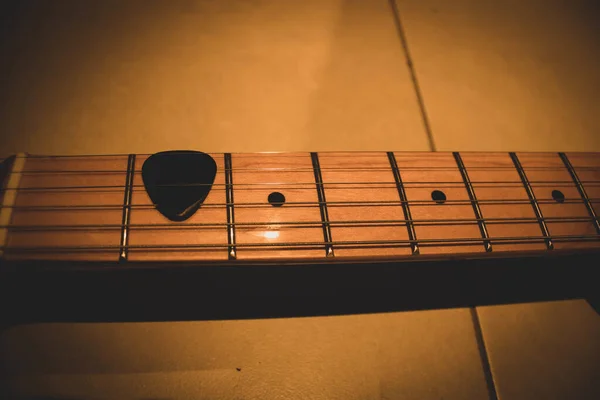 Eine Nahaufnahme Eines Picks Auf Einem Gitarrenhals Unter Dem Licht — Stockfoto