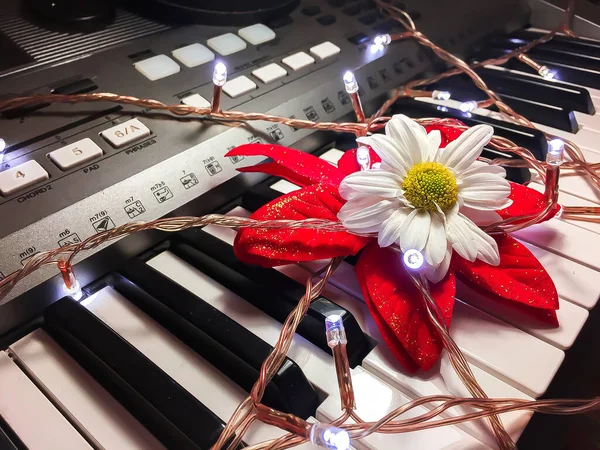 Närbild Julbelysning Och Konstgjord Blomma Ett Elektroniskt Piano — Stockfoto