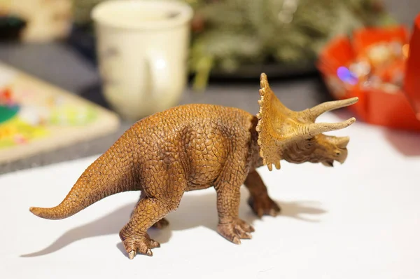 A selective focus shot of a dinosaur toy on the table