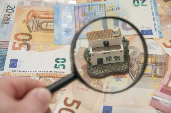 在欧元钞票背景下找到房子的放大镜 房地产评估的概念 — 图库照片